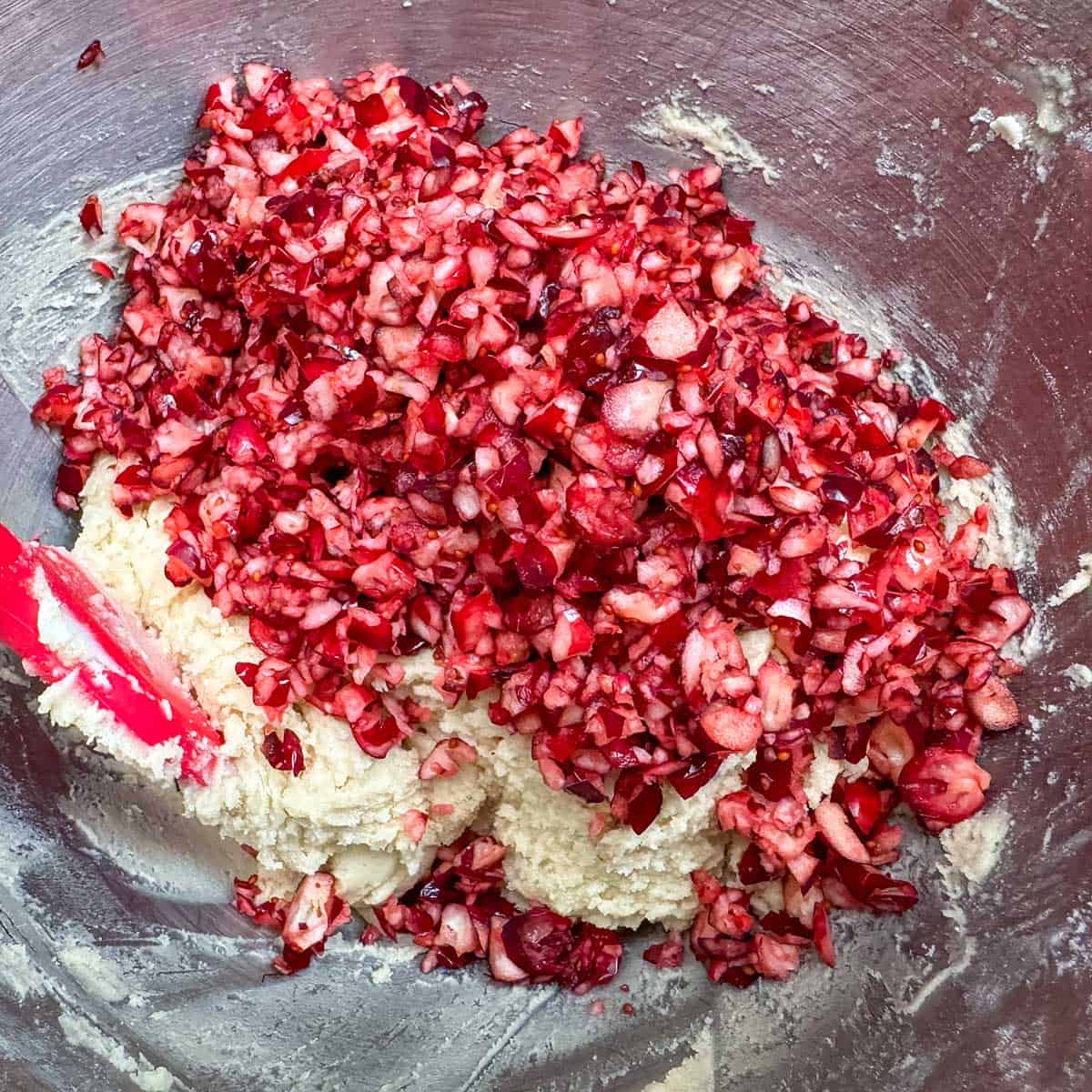 Chopped cranberries and walnuts going into the bowl with the cookie dough.