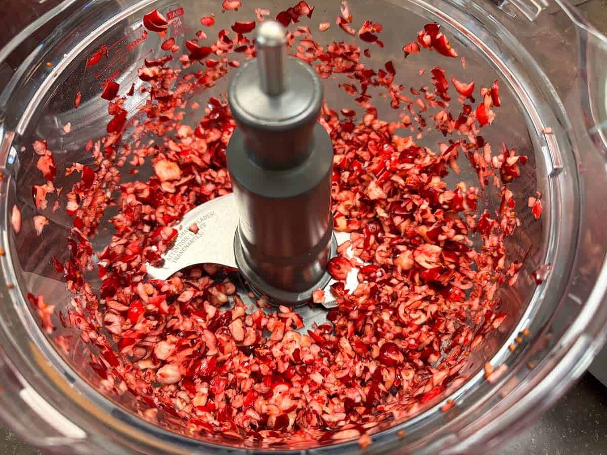 Chopped cranberries in a food processor bowl.