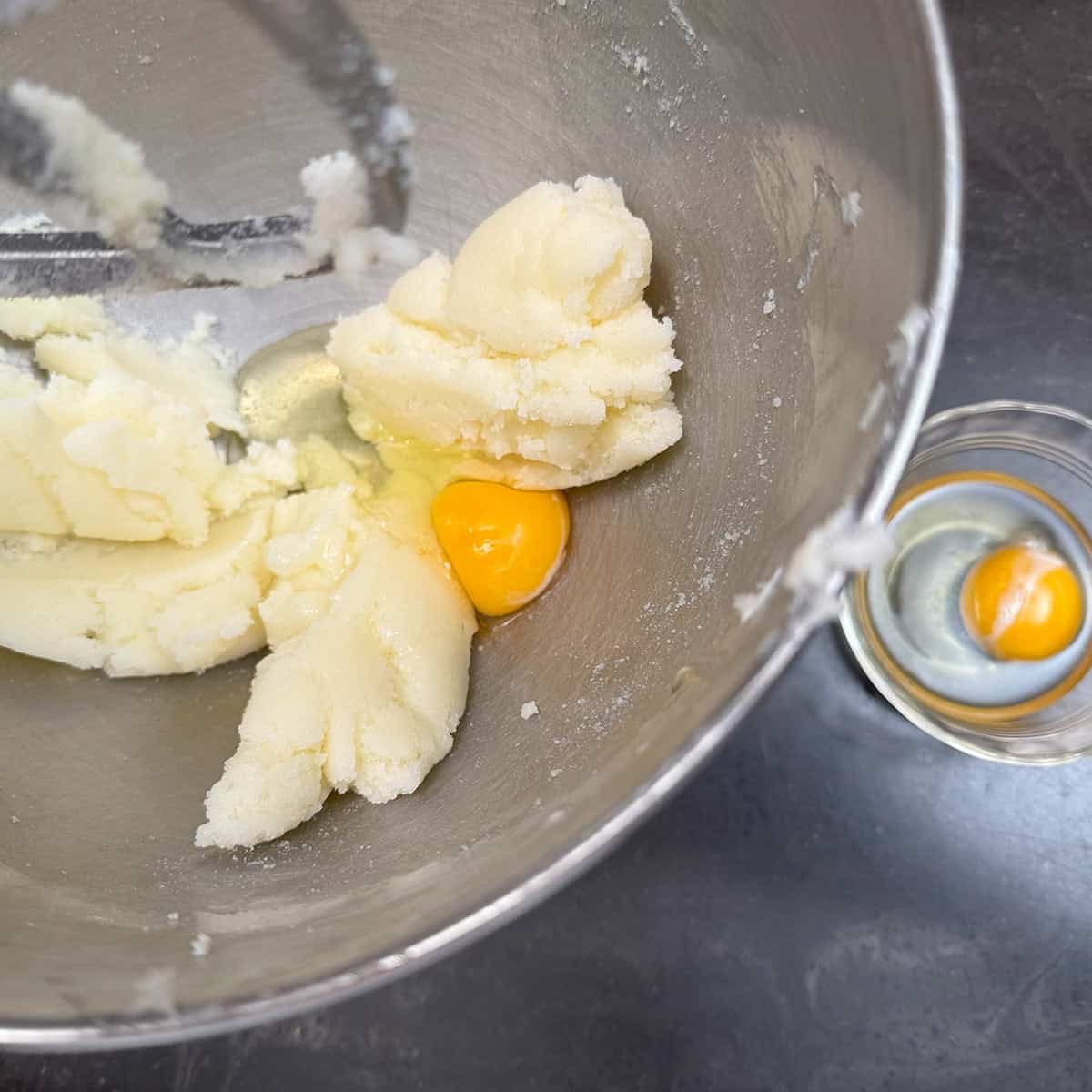 Adding eggs one at a time to the butter-sugar mix.