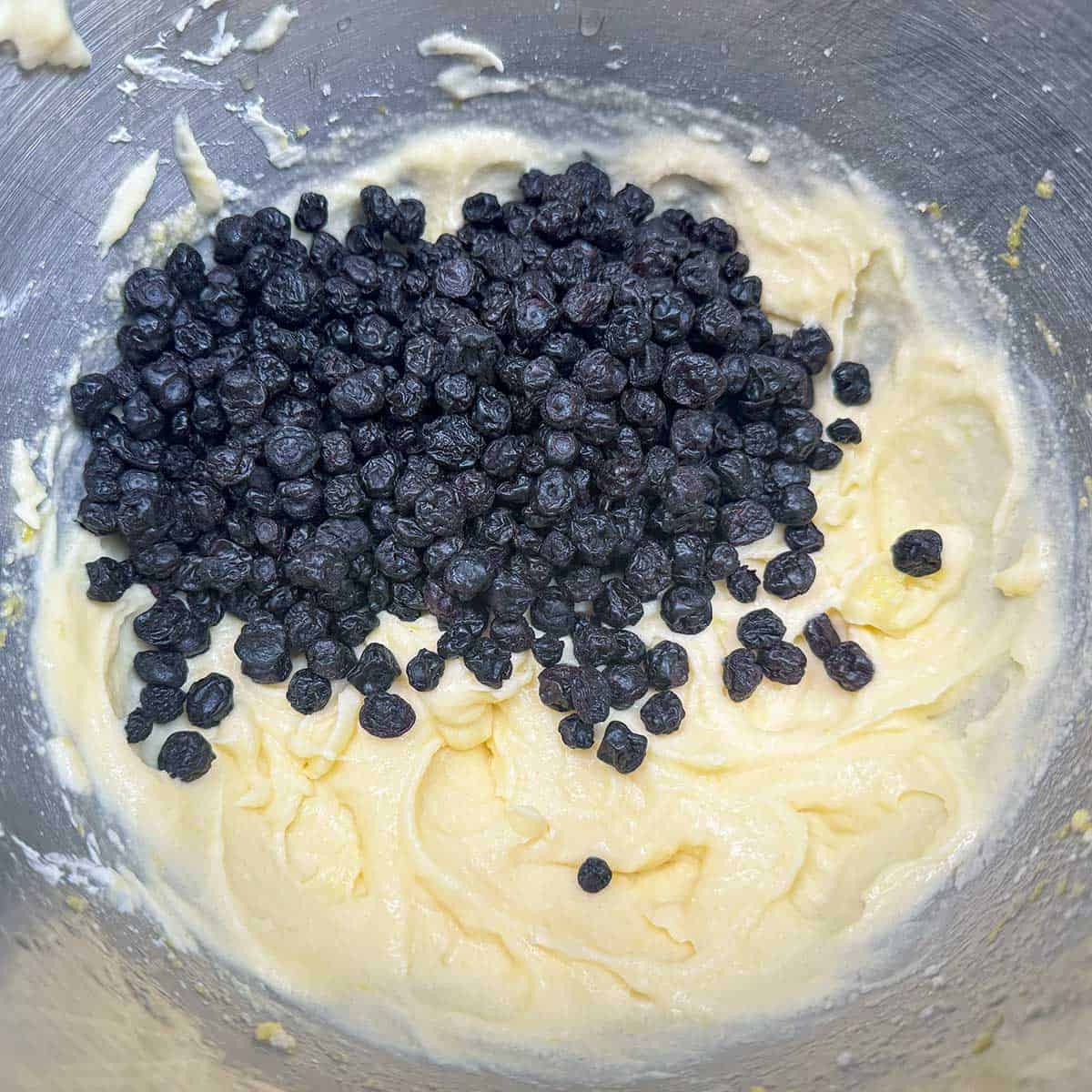 Adding dried blueberries to the soft cookie dough.