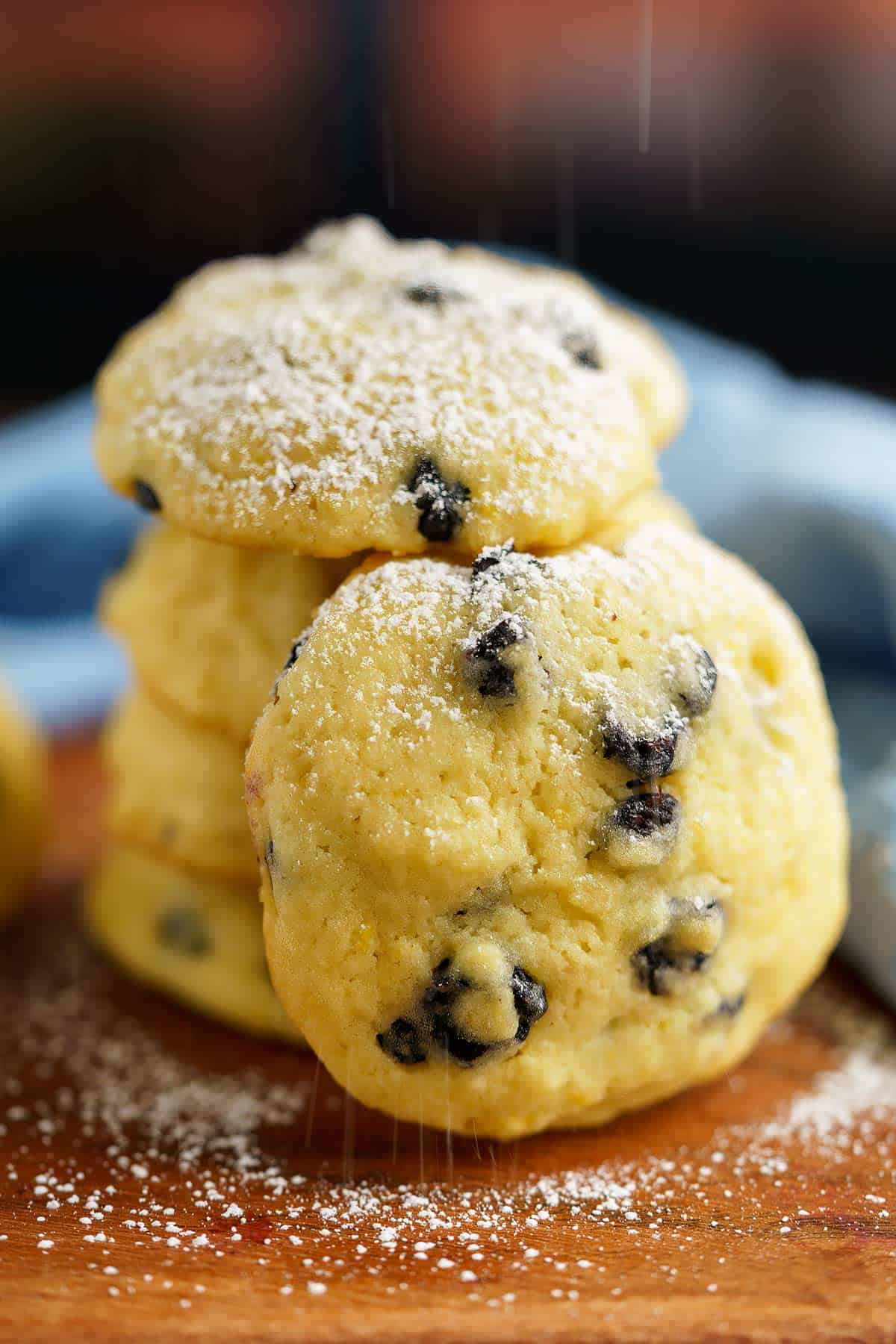 Stack of blueberry lemon with mascarpone cookies getting a sprinkle of powdered sugar.