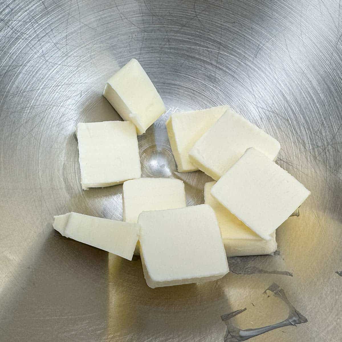 Sliced butter in a mixer bowl ready to be creamed.