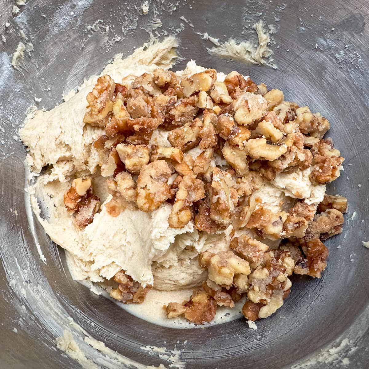 Adding glazed maple walnuts to the cookie dough.