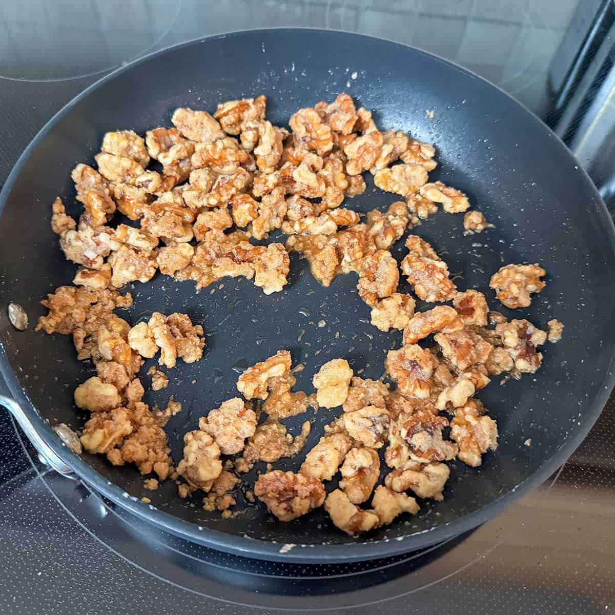 Final coating before taking the glazed walnuts off the stove heat.