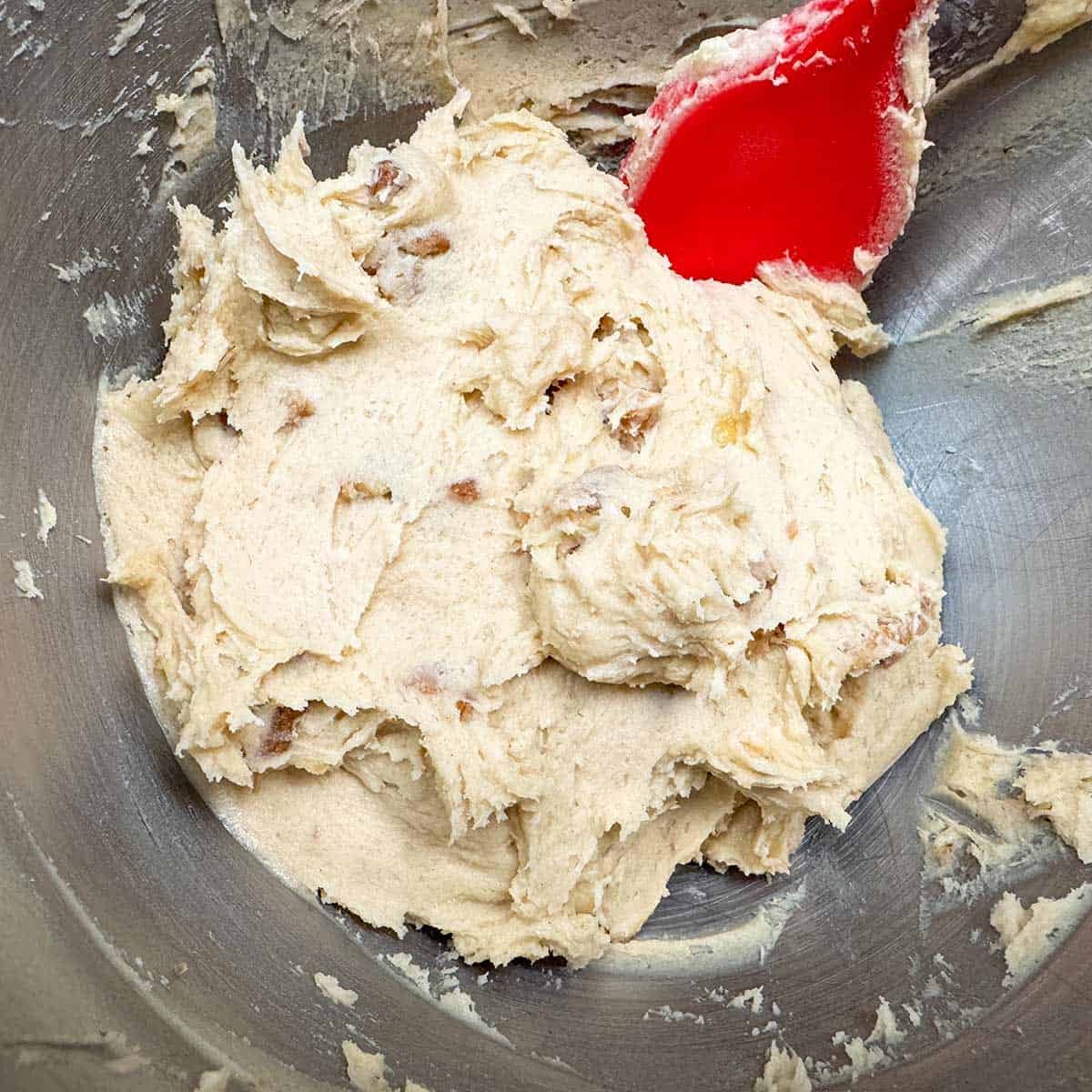 Cookie dough all mixed in a mixer bowl.