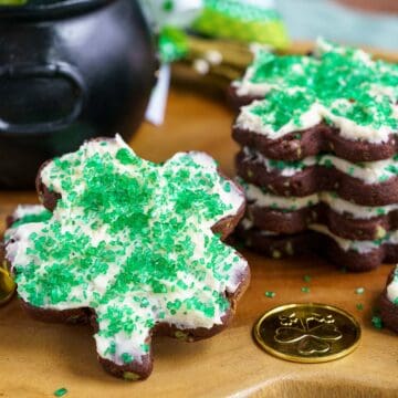 Shamrock shaped cookies with icing and sprinkles on top.