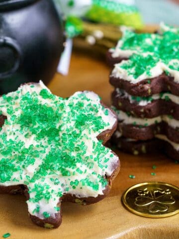 Shamrock shaped cookies with icing and sprinkles on top.