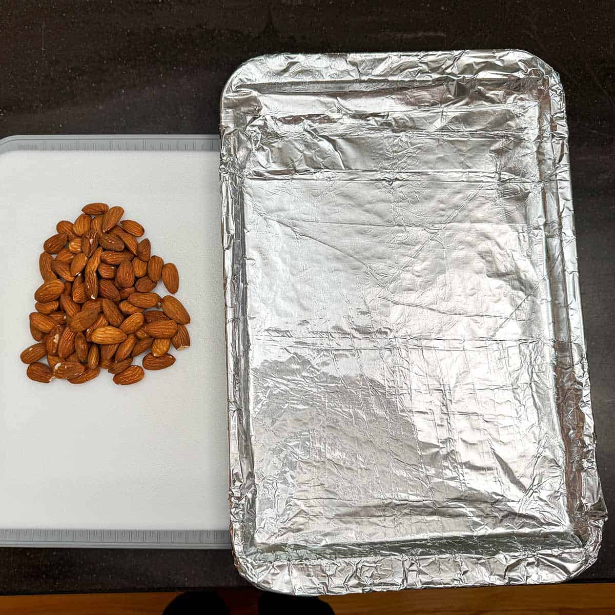 Whole almonds and the sheet pan that will roast the chopped almonds.