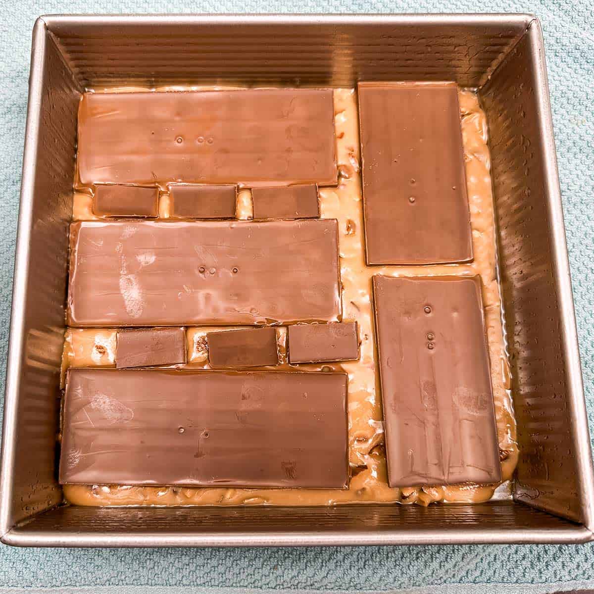 Laying the Hershey's bars on top of the hot toffee to melt.