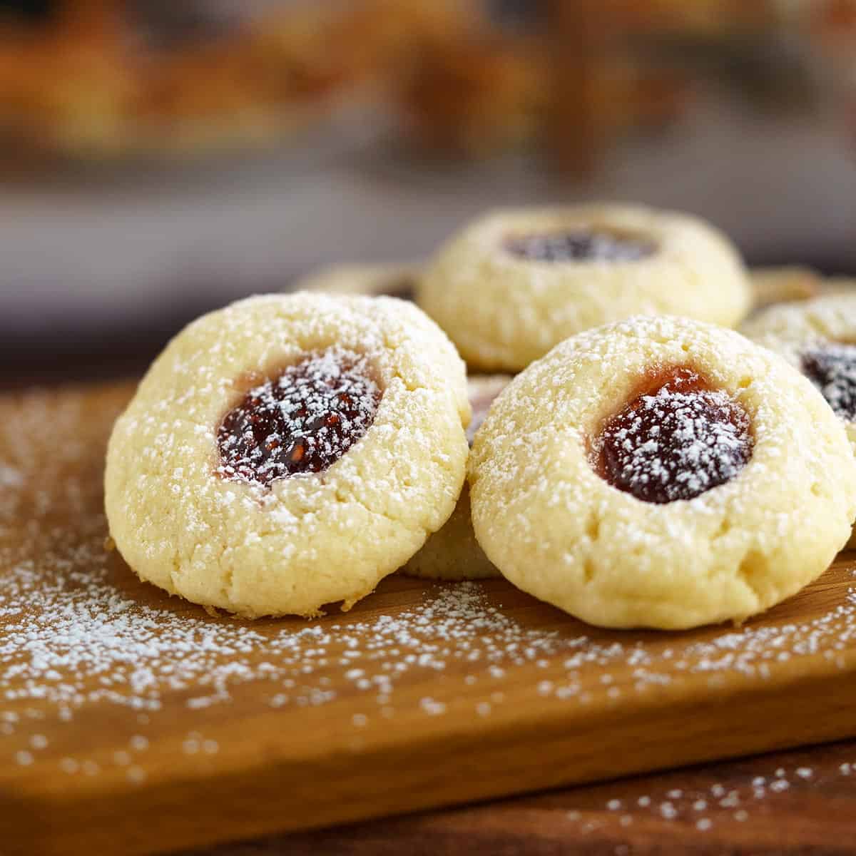 A group of Raspberry Cream Cheese Cookies on a wooden board.