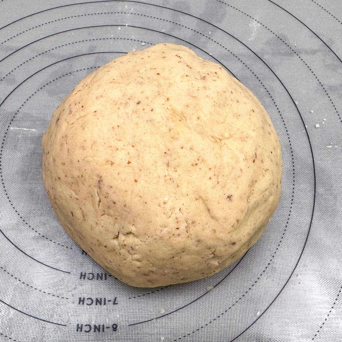 Making a large ball of the cookie dough so that the butter can help soften the almond pieces.