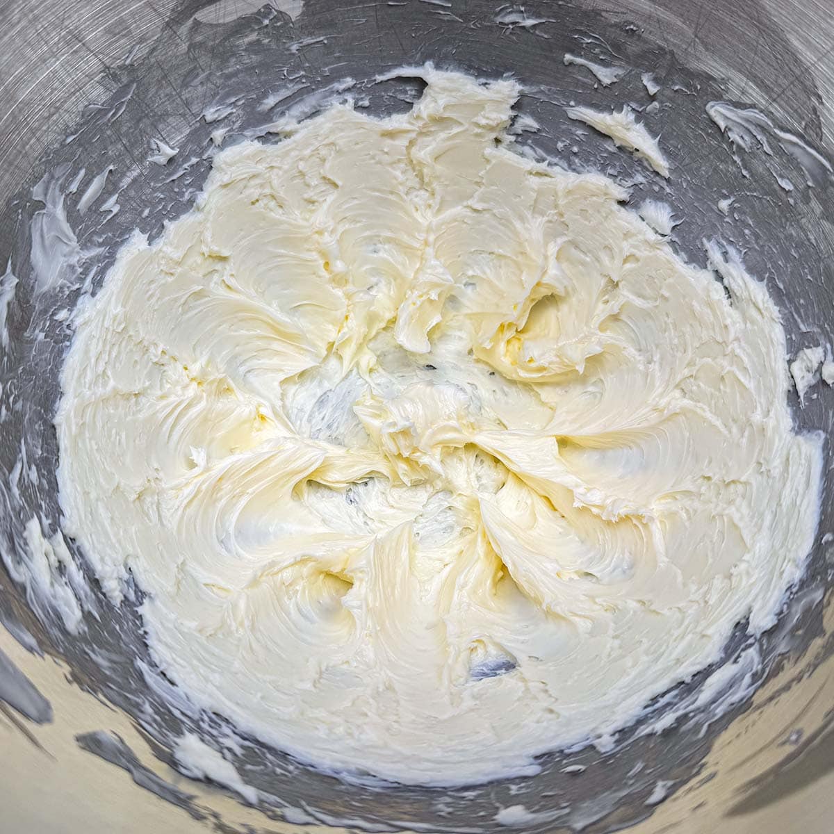 Butter that has been creamed with soft peaks, in the mixer bowl.