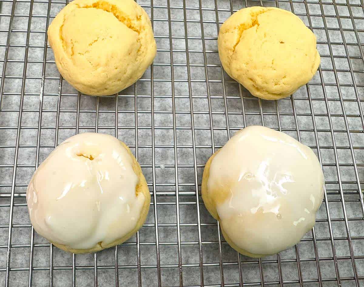 Four cookies on a rack, two have icing and two do not.