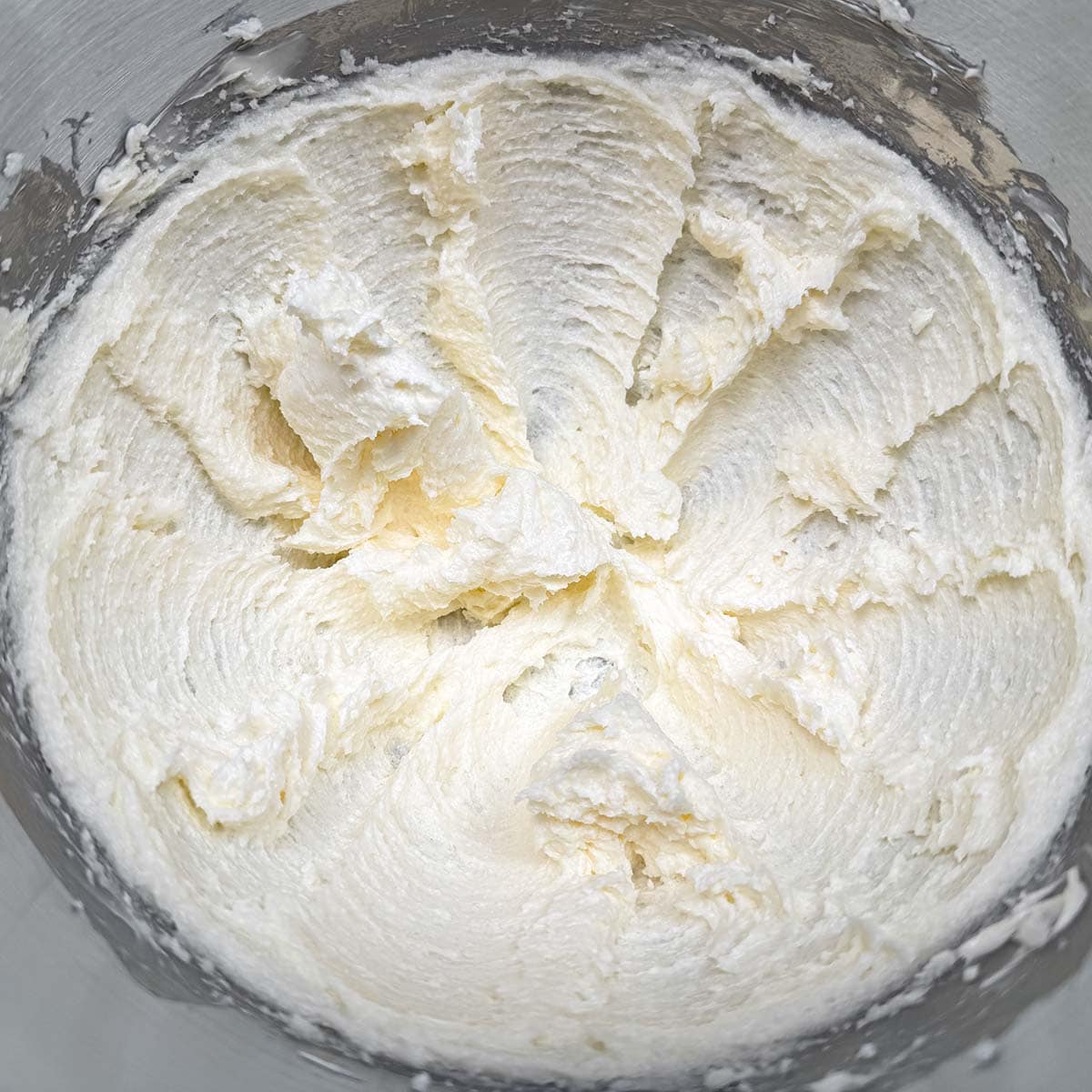 Creamed butter and sugar mixed in bowl.