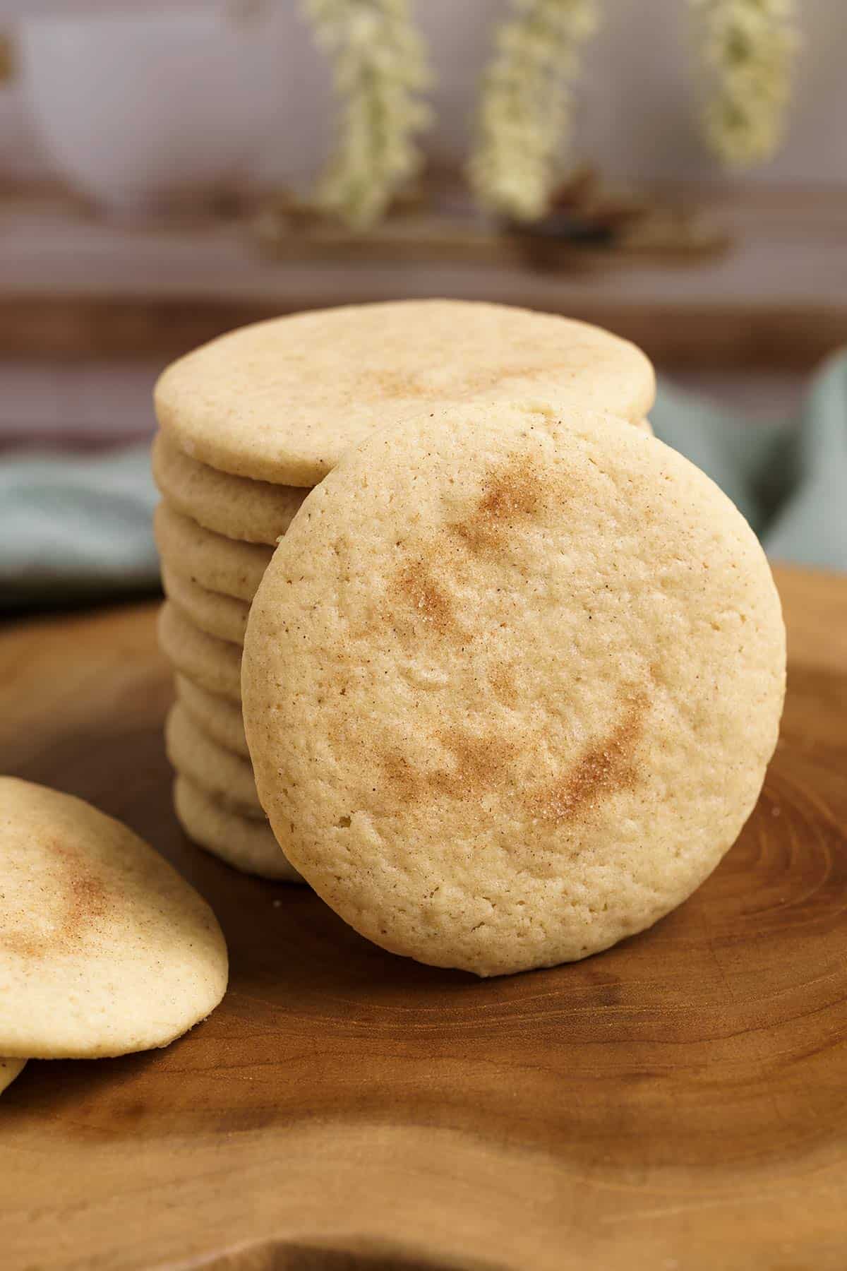 Apple cinnamon sugar cookies on a wooden board with a closeup of cookie standing on edge.