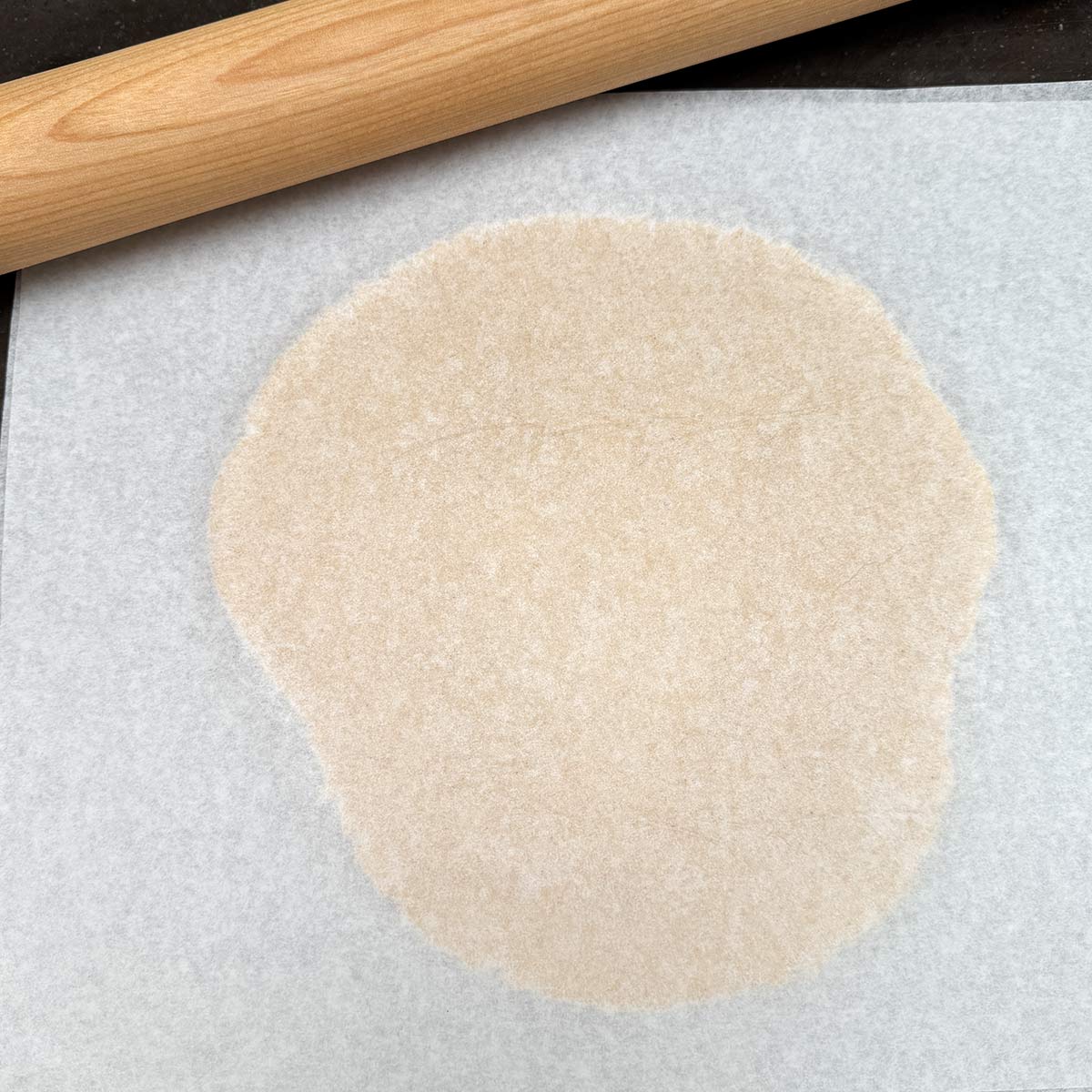 Rolling out cookie dough between 2 sheets of parchment paper.