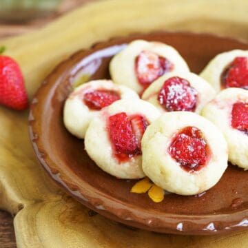 Fresh strawberry and jam cream cheese cookies on a plate close up.