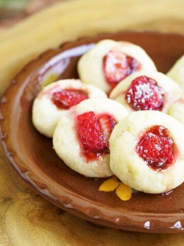 Fresh strawberry and jam cream cheese cookies on a plate close up.