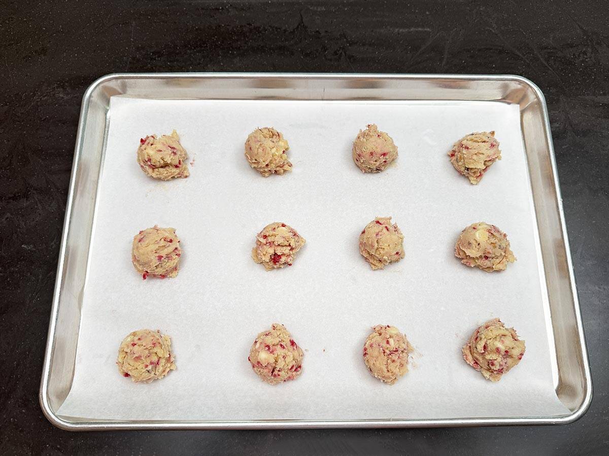 Scooped cookie dough onto a parchment lined sheet pan ready to be baked.