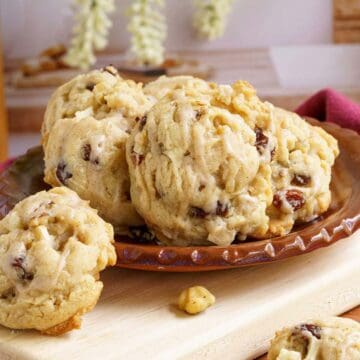 Apple cider cookies sitting on a flat plat on top of a wooden board.