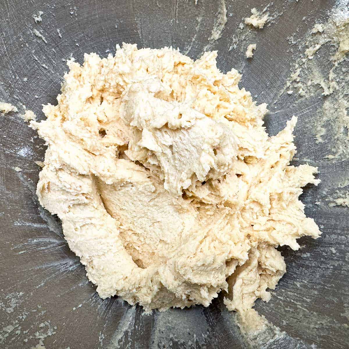 Cookie dough mixed and scraped down sides in mixer bowl.