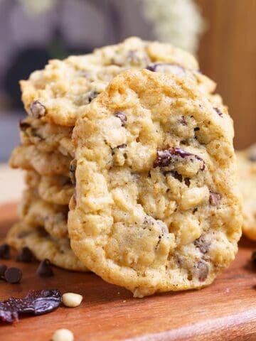 Everything in the bowl oatmeal cookies stacked on a wooden board.