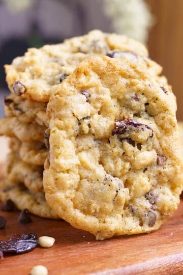 Everything in the bowl oatmeal cookies stacked on a wooden board.