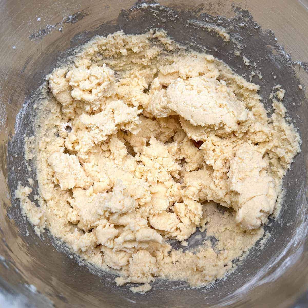 Cookie dough in mixer after mixing in flour mixture. Lots of dry flour bits.