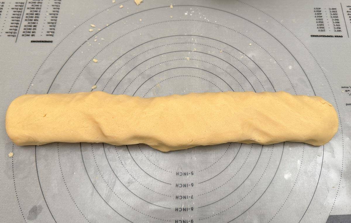 Cookie dough in a log shape after kneading all the bits of flour.
