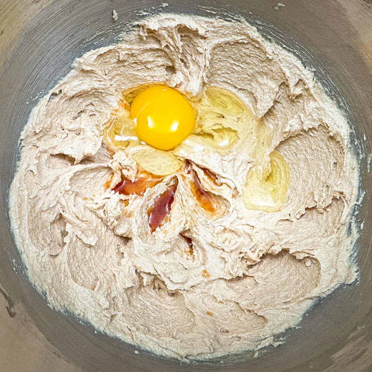 Adding the egg and the vanilla extract to the wet mixture.