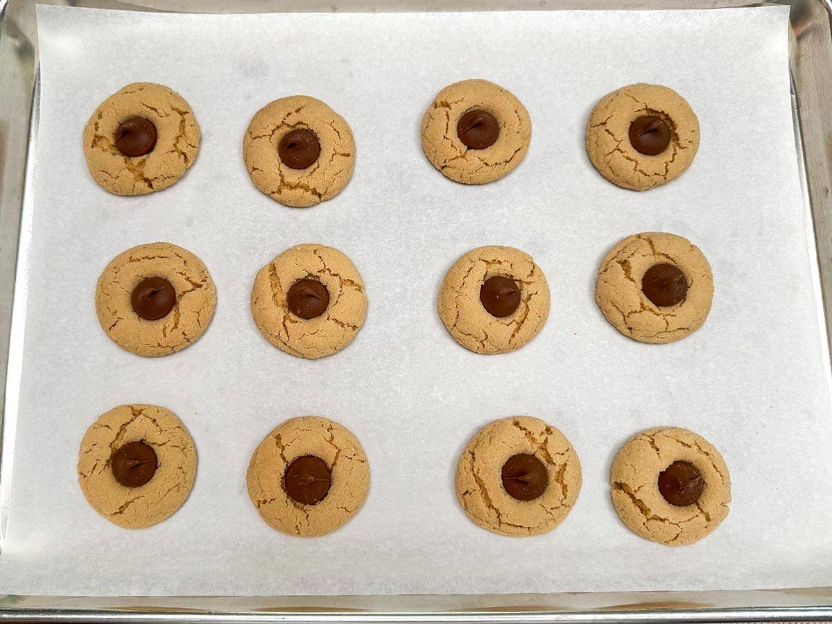 Adding Wilbur Milk Chocolate Buds onto Peanut Butter cookies.