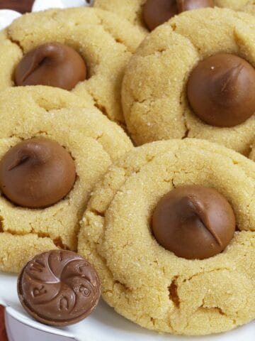 Five completed Peanut Butter Blossom Cookies on dish.