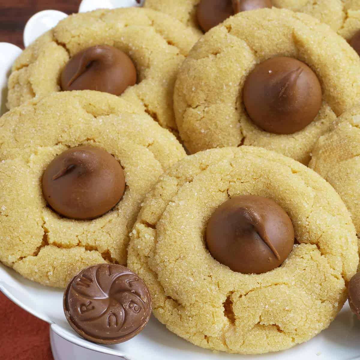 Five completed Peanut Butter Blossom Cookies on dish.