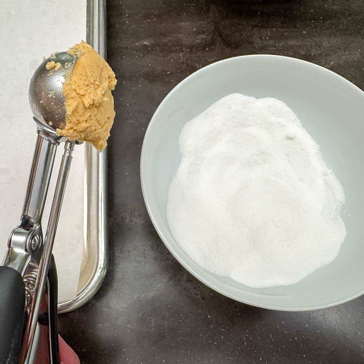 A small cookie scooper with cookie dough.