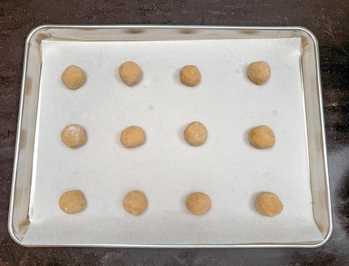 Blossom balls rolled in sugar and placed on a parchment lined sheet pan.