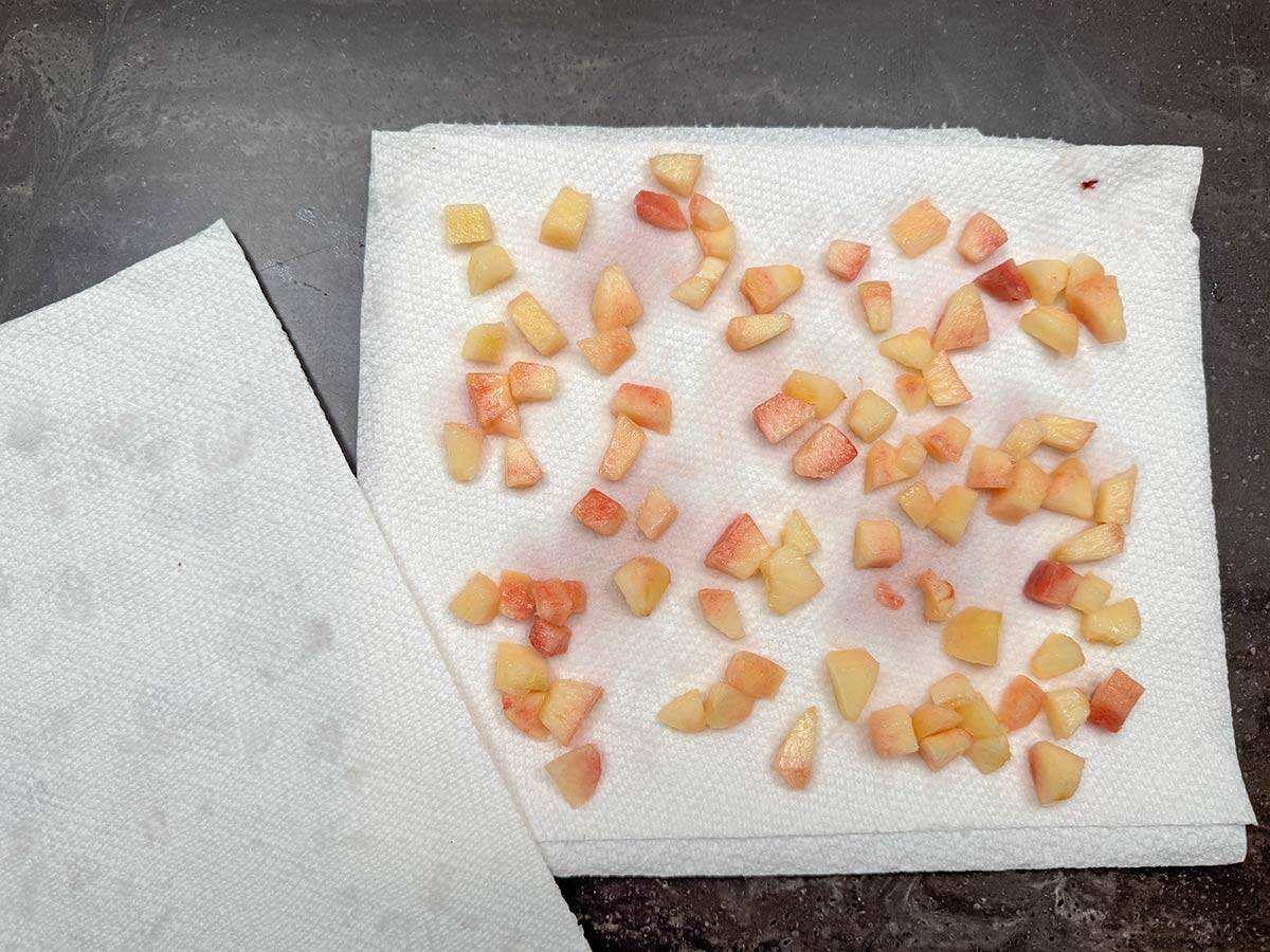 Cutup peach pieces laid out on a paper towel.
