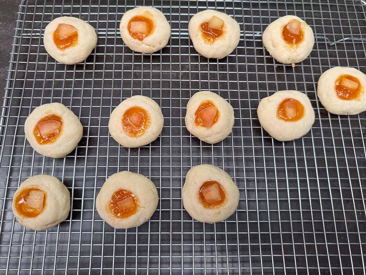 After being baked and on cooling rack with piece of fresh peach added to the top of the preserves.
