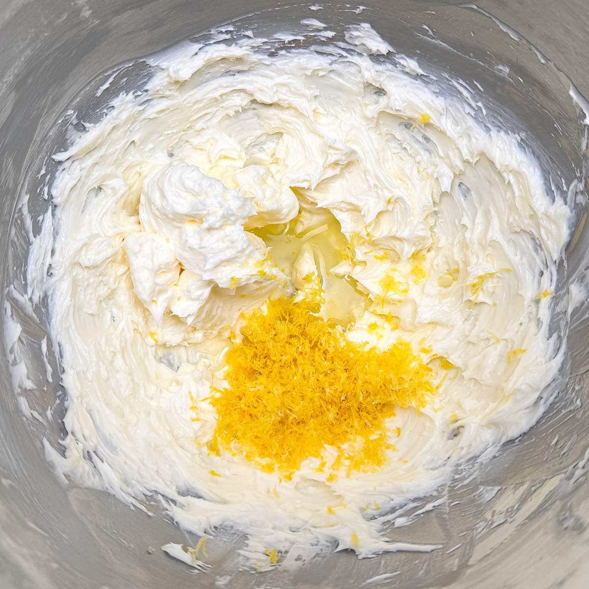 Adding lemon zest and juice to the butter sugar mixture.