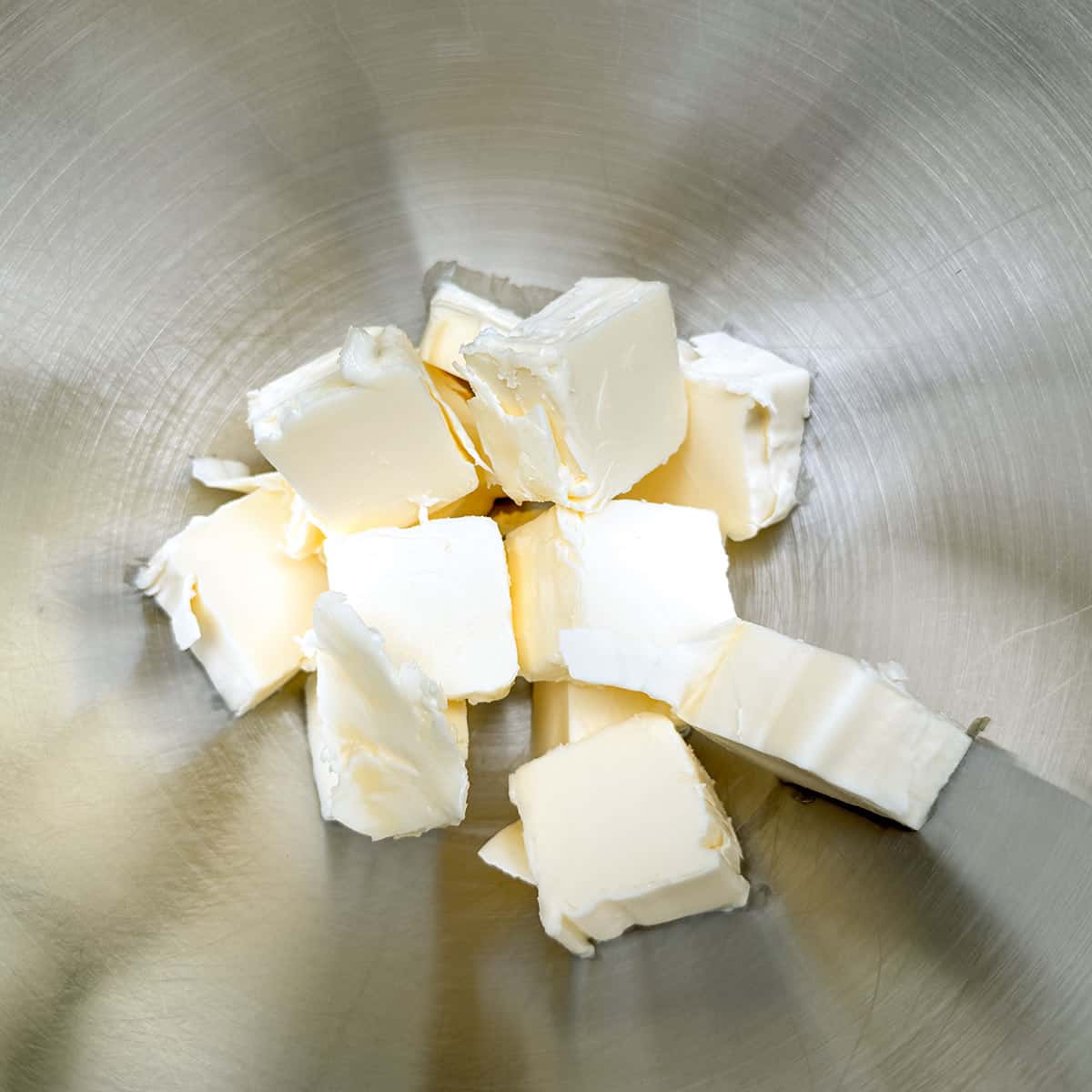 Cubed butter in a mixer bowl.