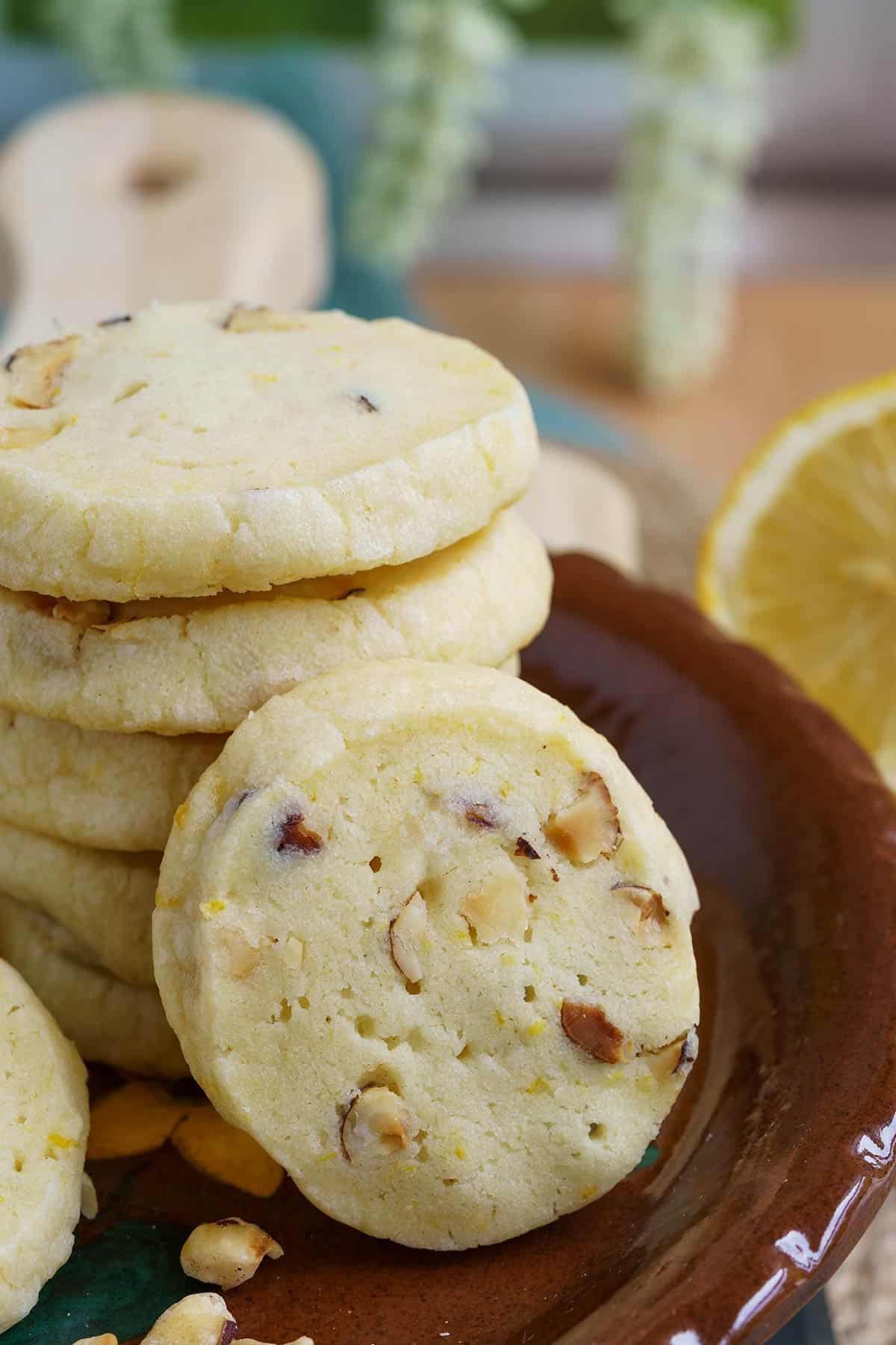 Lemon ginger with hazelnuts shortbread cookies stacked and on a small plate.