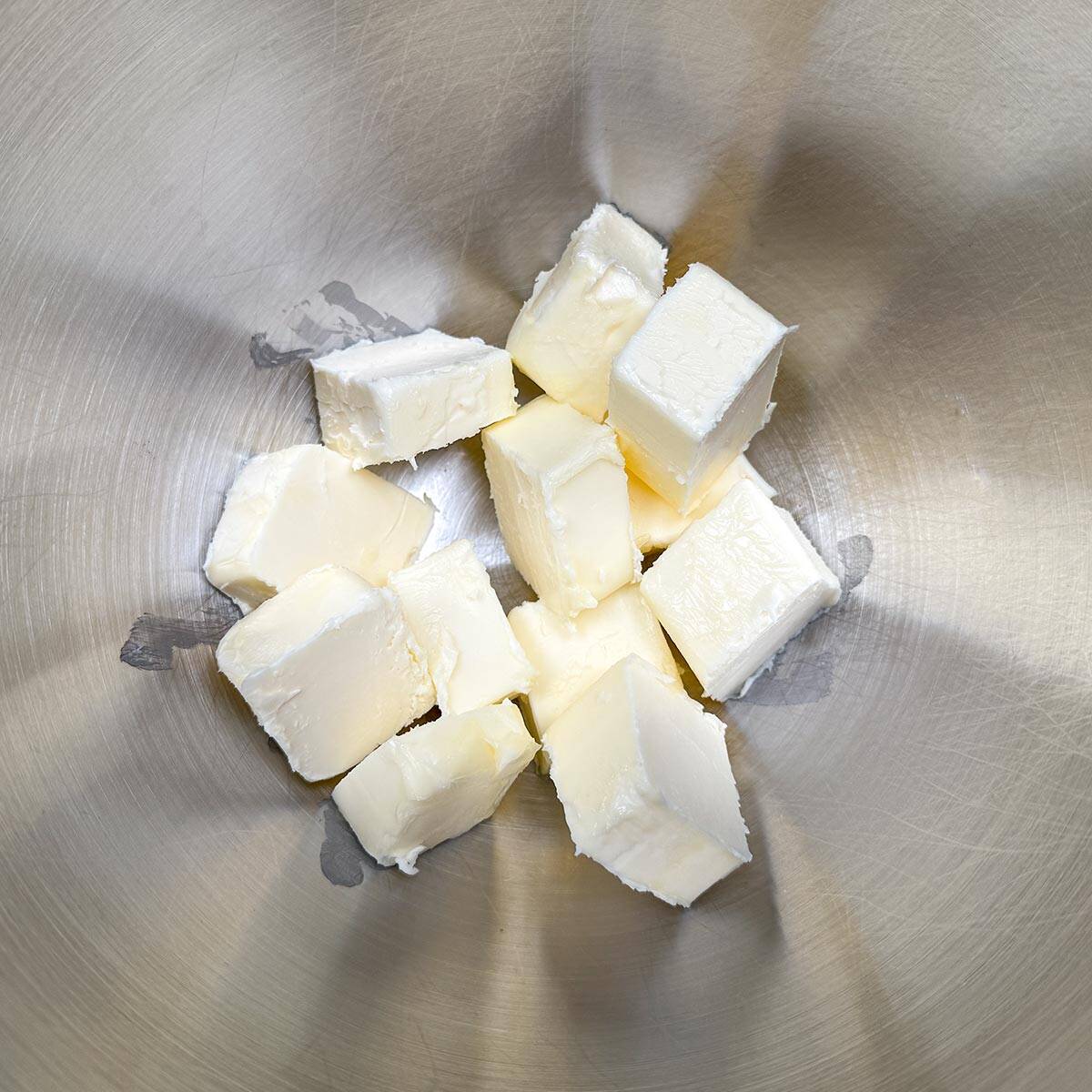 Room temperature butter that has been cubed and in a mixer bowl.