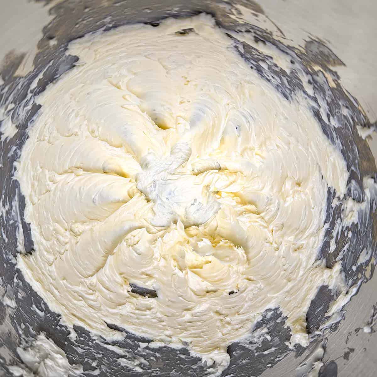 Butter that has been creamed and looks creamy with soft peaks in the mixer bowl.