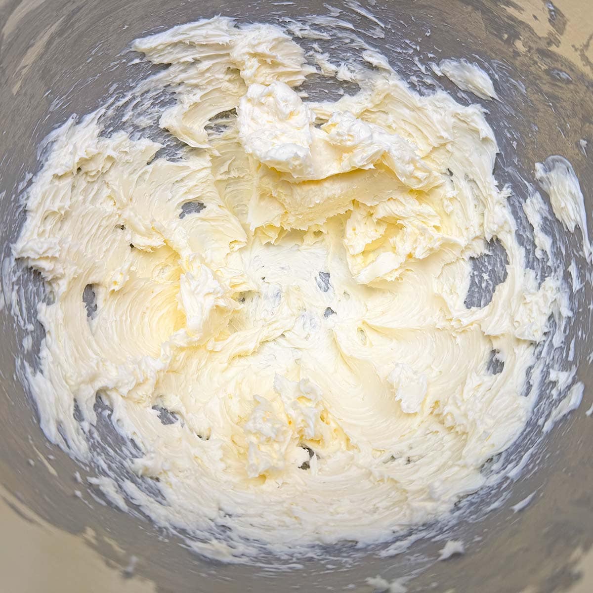Cubed butter that has been mixed for one minute and is now in a creamed state.