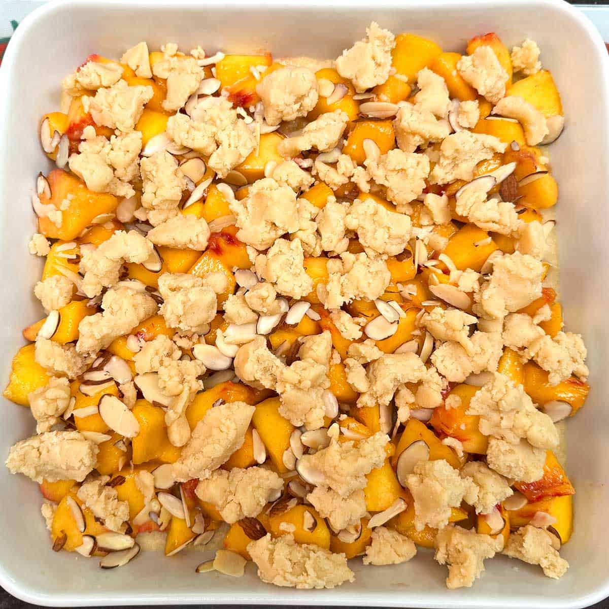Final topping of shortbread pieces on top of the peaches and almonds.