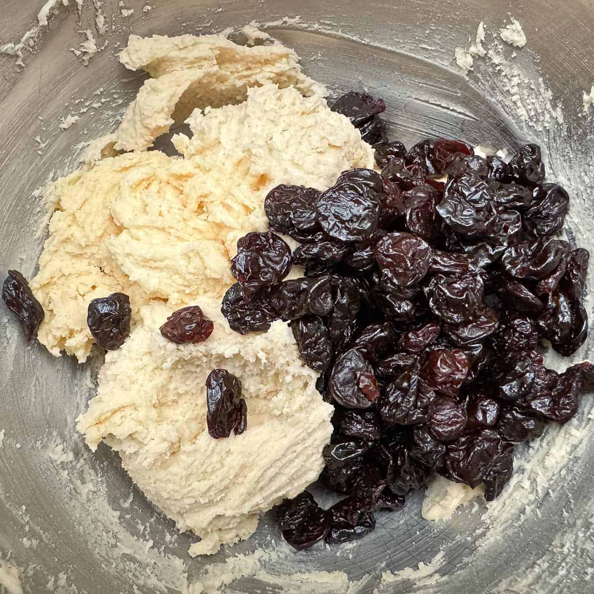 Adding dried cherries to the cookie dough.