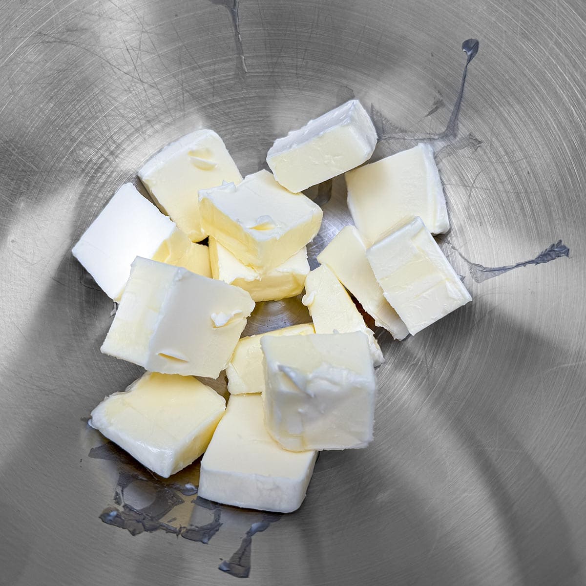 Cubed butter that is in a mixer bowl ready to be creamed.