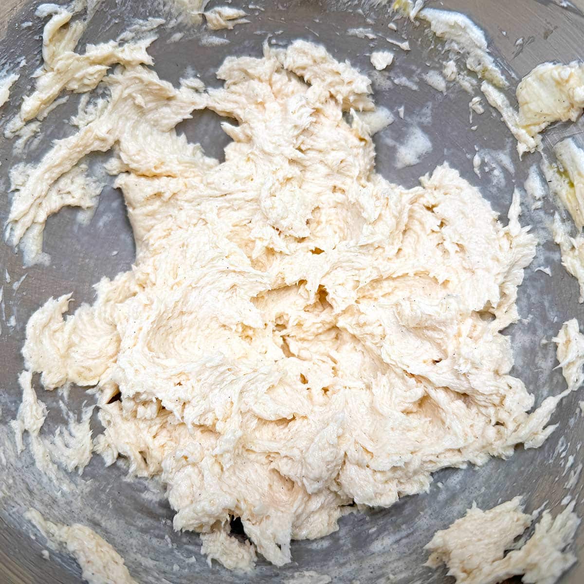 Dough after the egg and vanillas have been incorporated and does not look like strings of egg whites.