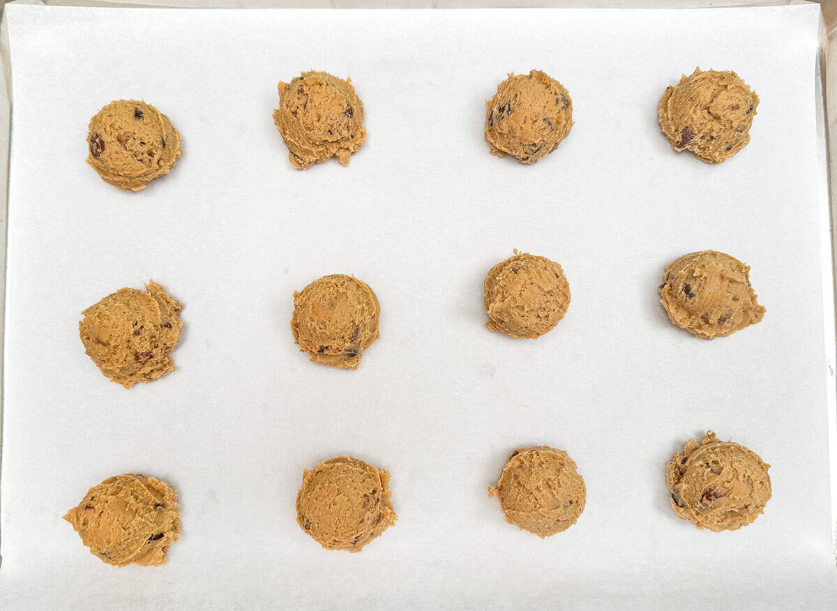 Scooped cookie dough onto a parchment lined sheet pan.