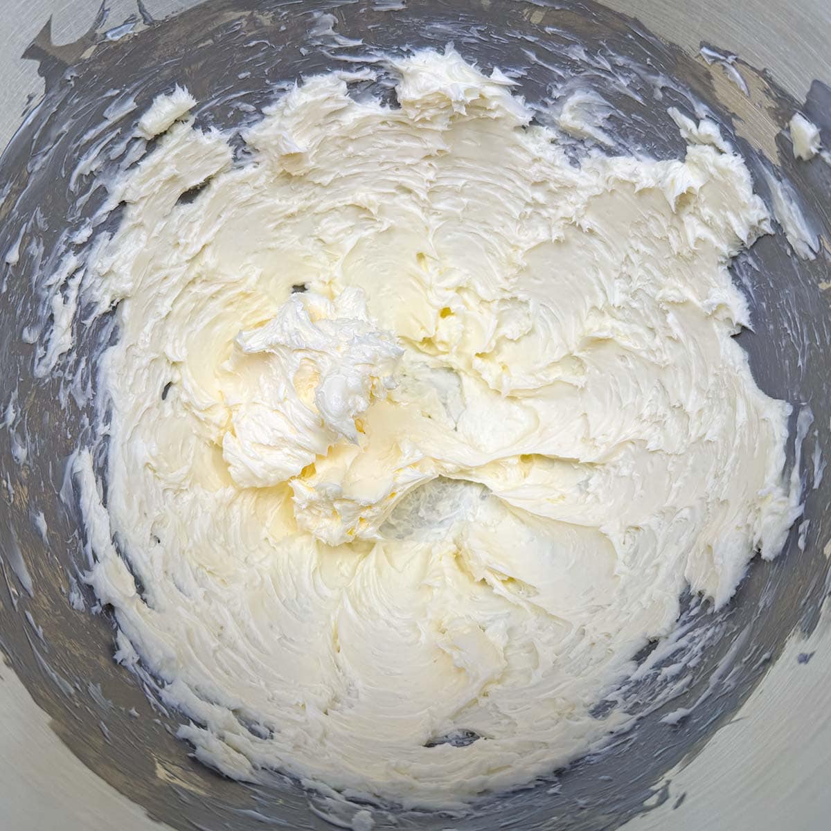 One cup of cubed butter that has been creamed with fluffy peaks.