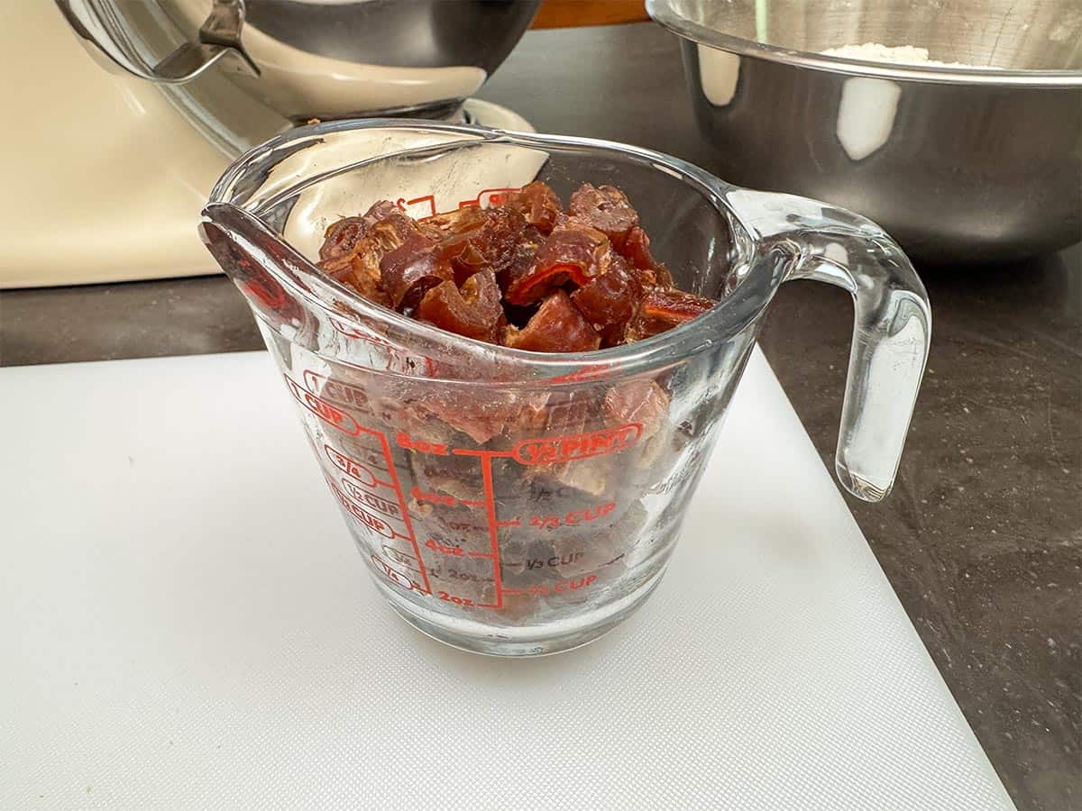 Cut up dates in a measuring cup.